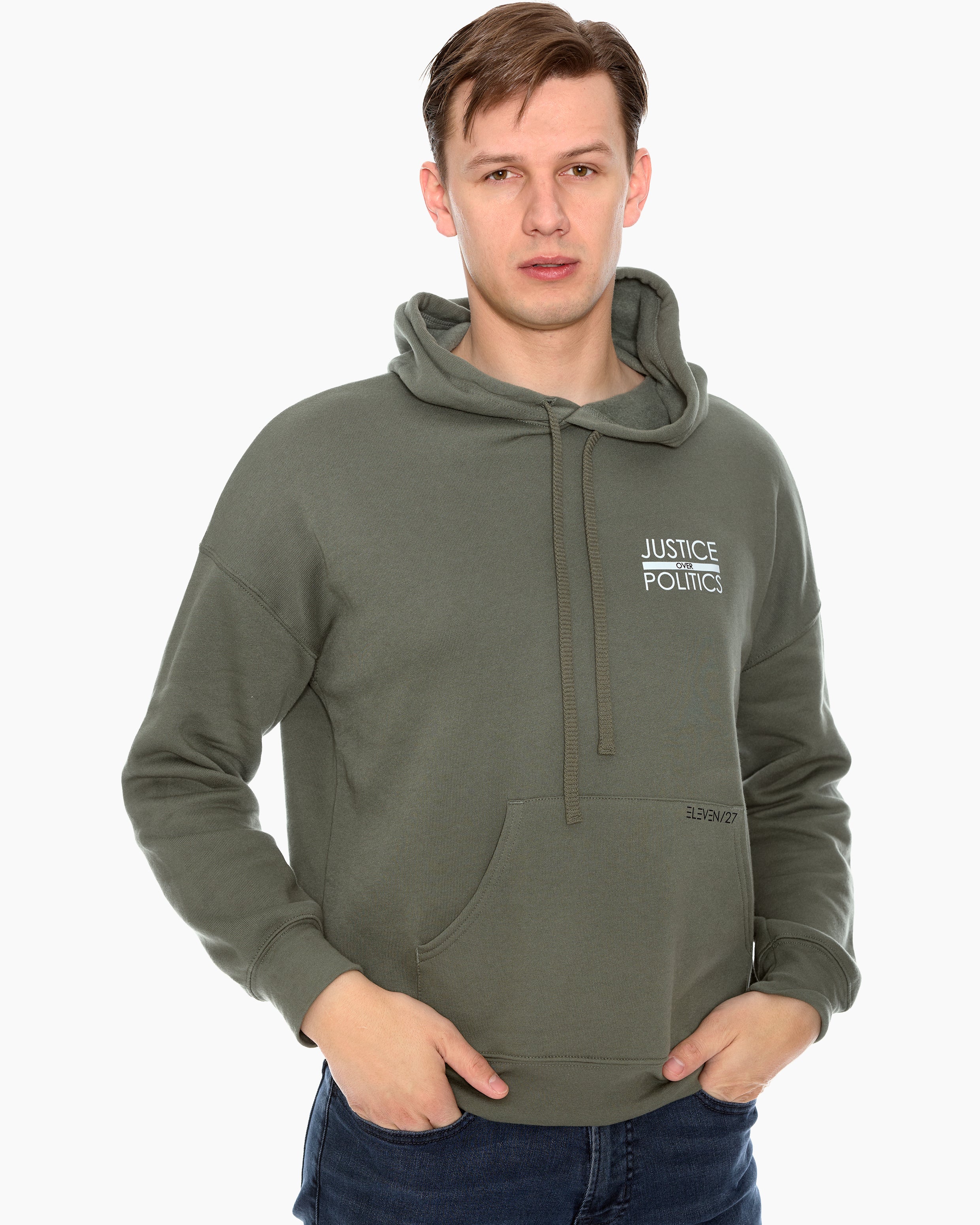 A male model wearing a green full-length hoodie with a "Justice Over Politics" graphic on the front and a logo on the back, featuring a front kangaroo pocket and drop shoulder design.