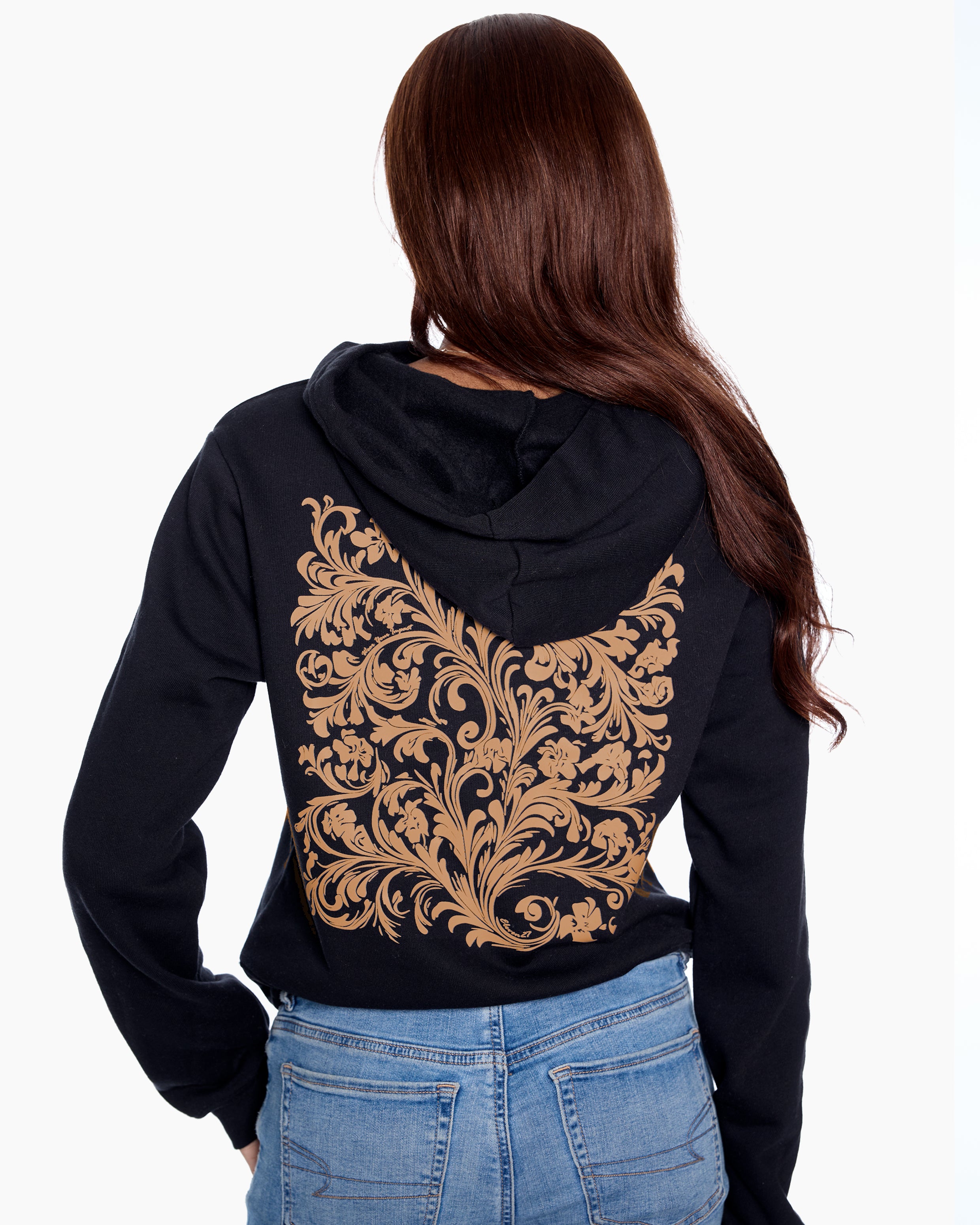 Person wearing a black hoodie with gold intricate design on the back, standing against a white background.
