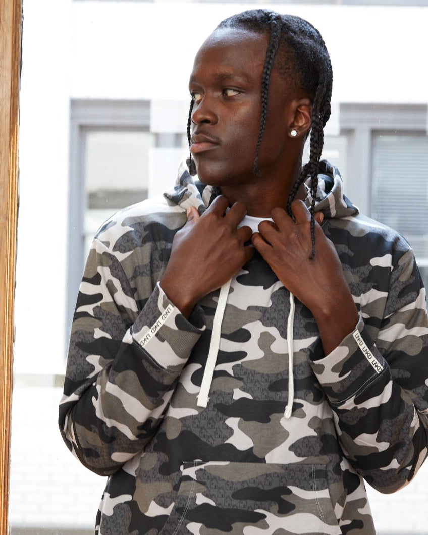 African American model wearing Shades of grey Camo printed full length hoodie. Contrast hoodie pulls. Long Sleeves.