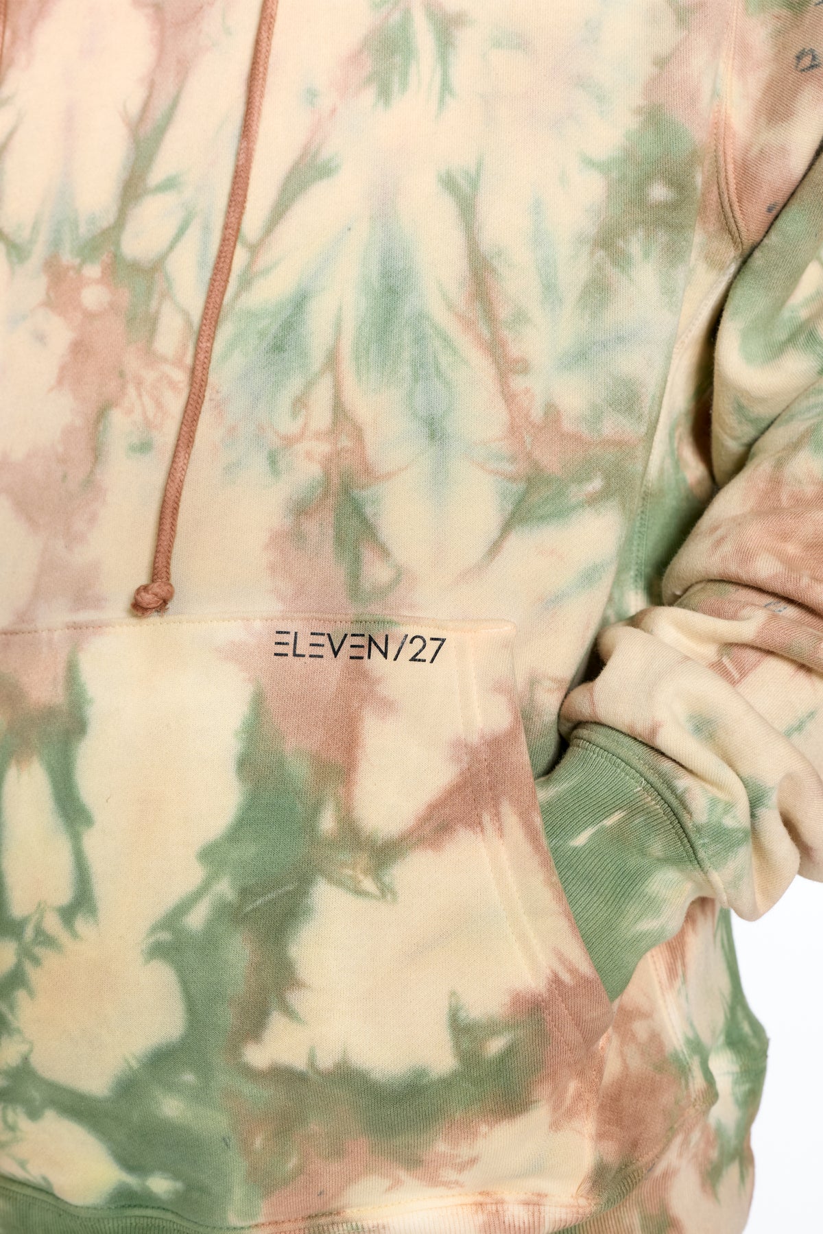 Tie-dye hoodie with 'ELEVEN/27' branding on a white background