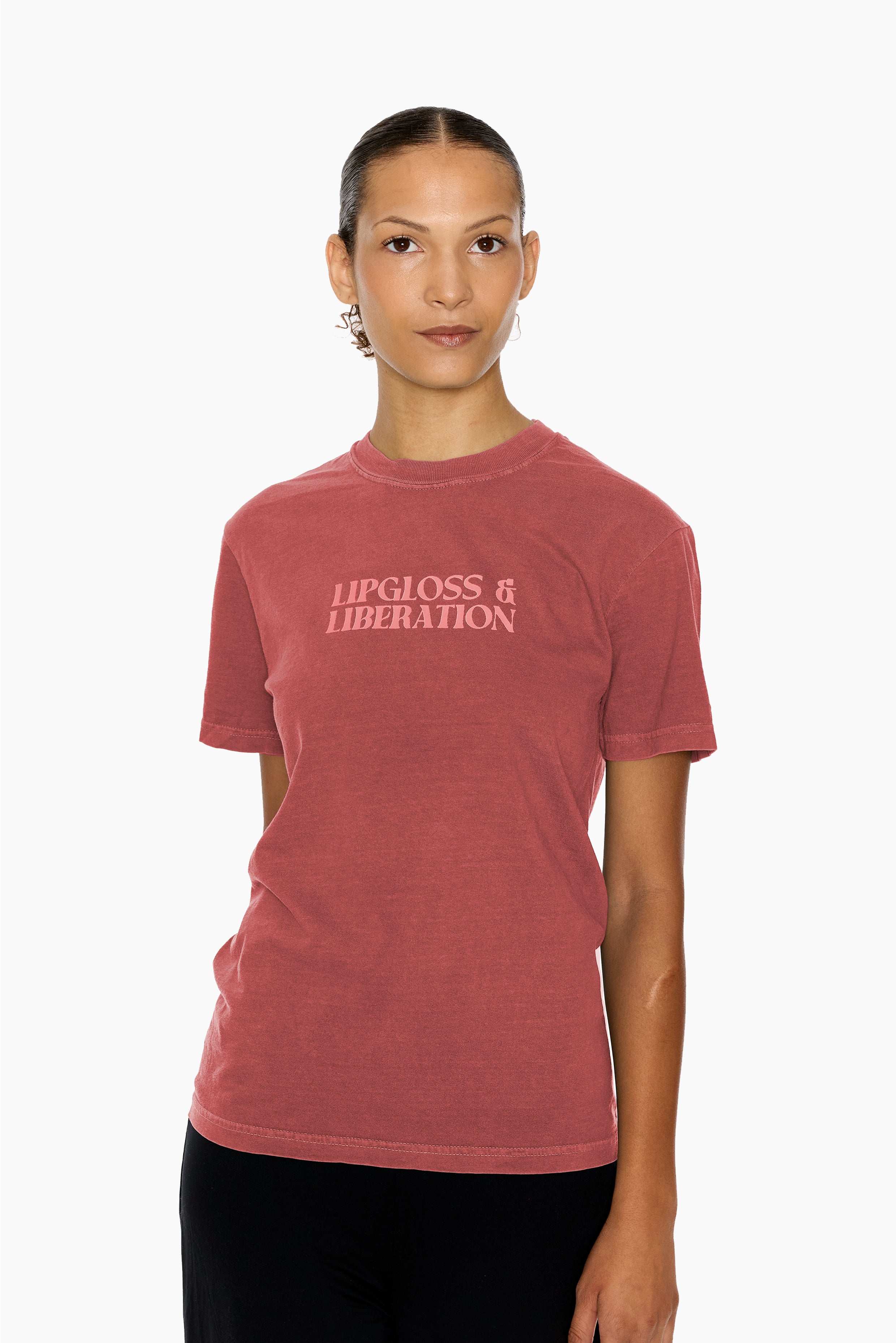 Person wearing a clay red t-shirt with 'Lipgloss & Liberation' text on a white background