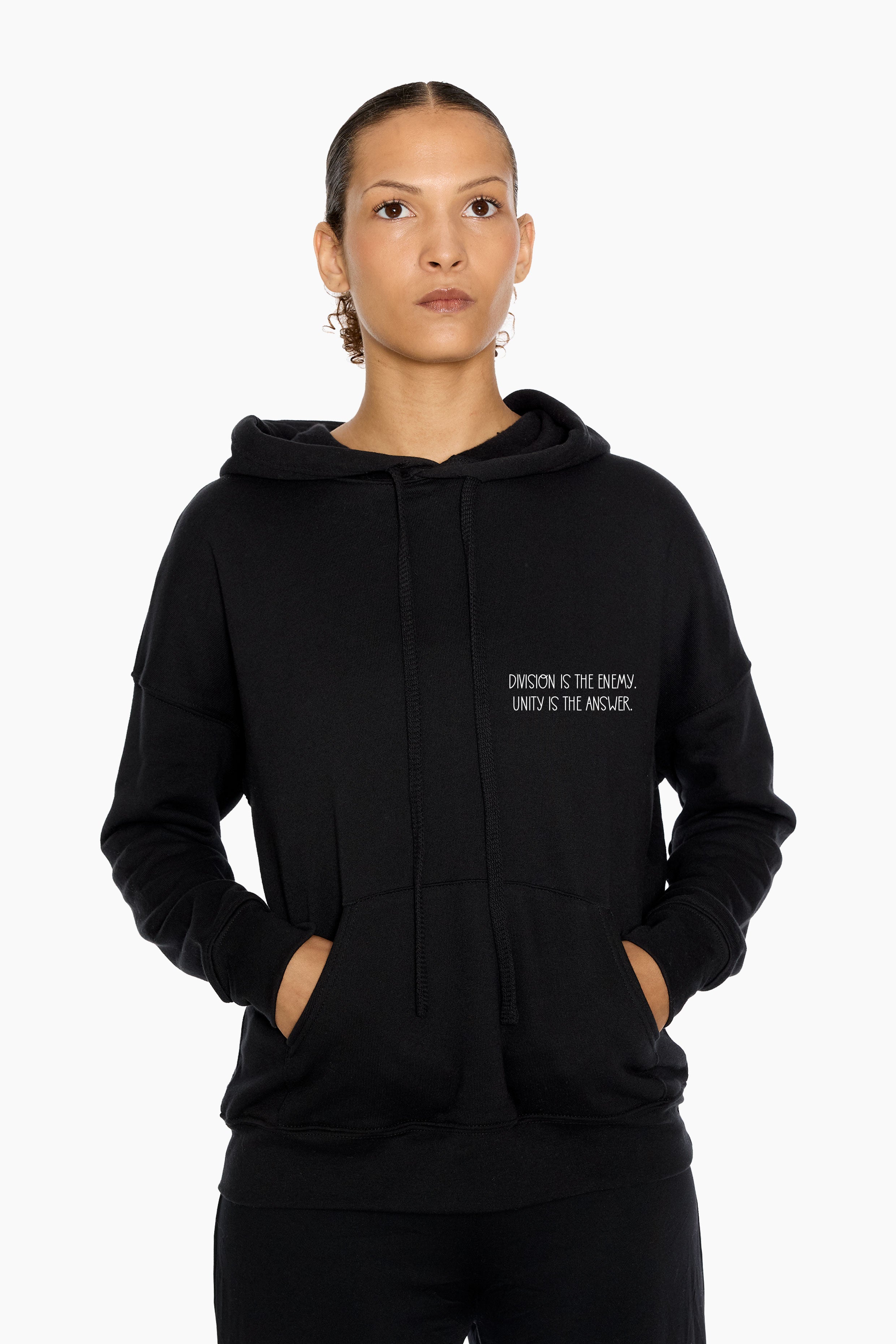 Person wearing a black hoodie with "Divinsion Is The Enemy, Unity Is The Answer", white background