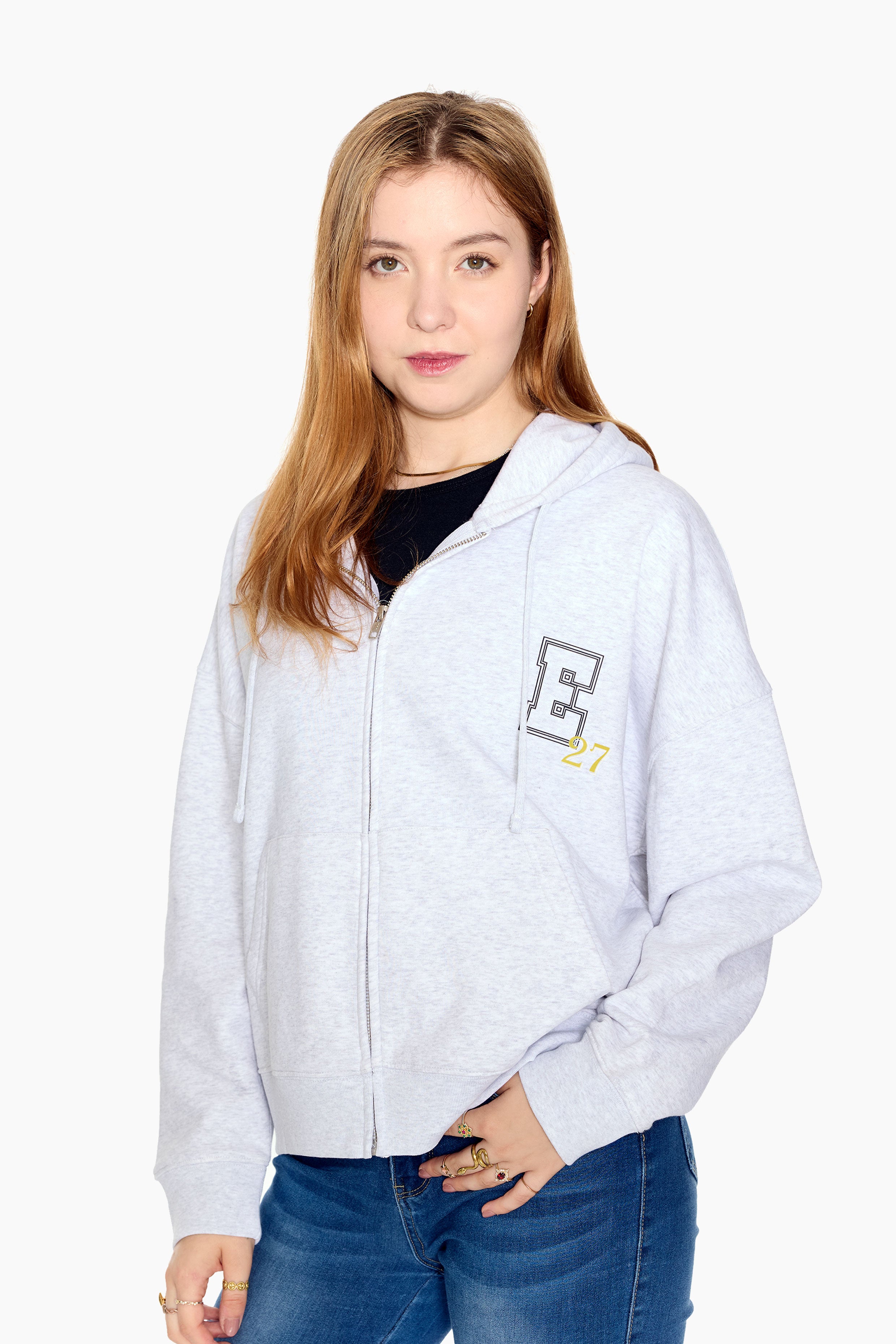 Woman wearing a light gray hoodie with a E27 logo on a white background