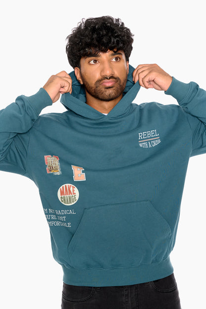 Man wearing a teal hoodie with text and graphics on a white background
Eleven27 French Terry hooded sweatshirt with patch-style graphics on the front.