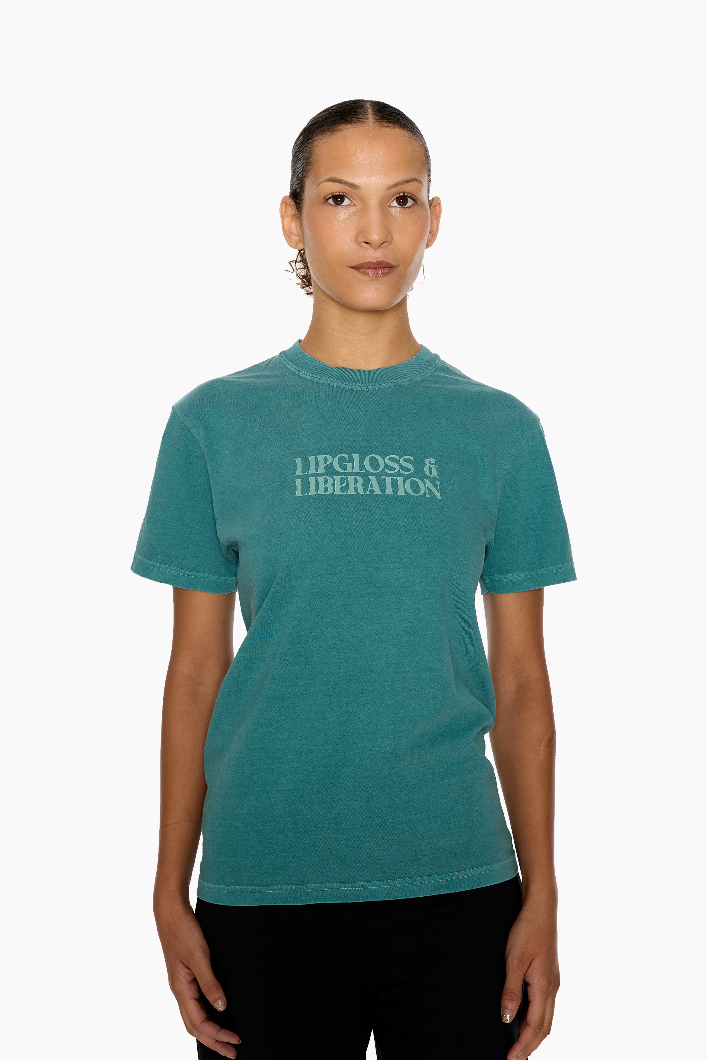 Person wearing a green t-shirt with 'Lipgloss & Liberation' text on a white background