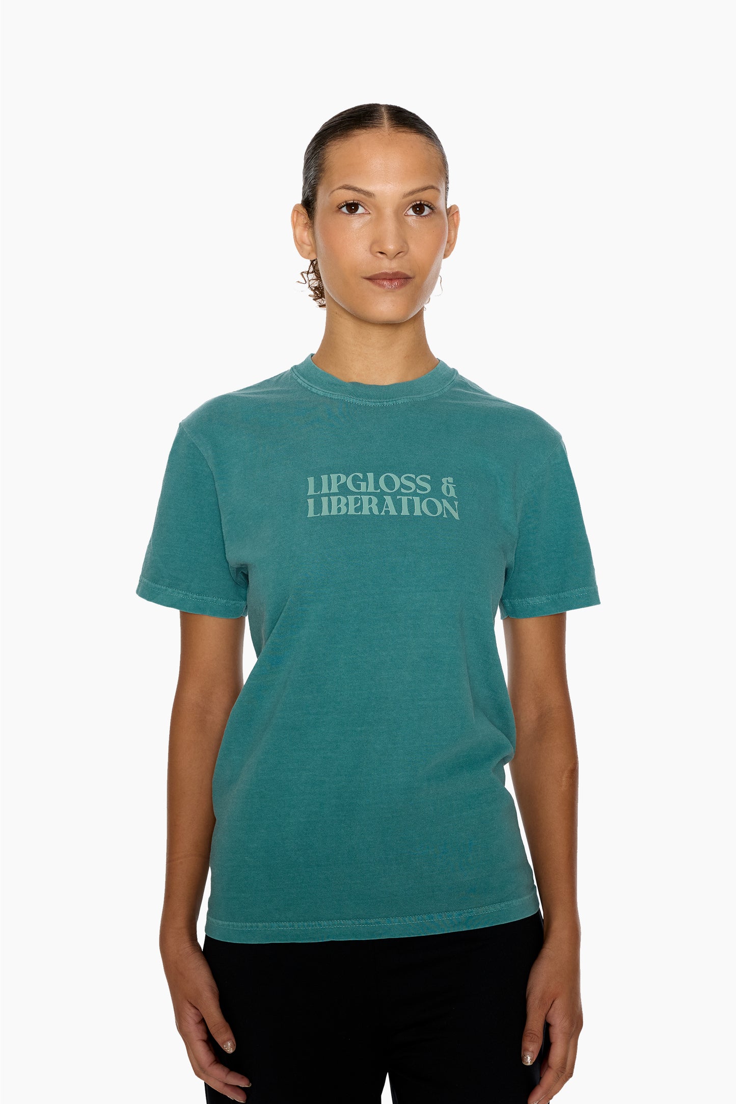 Person wearing a green t-shirt with 'Lipgloss & Liberation' text on a white background