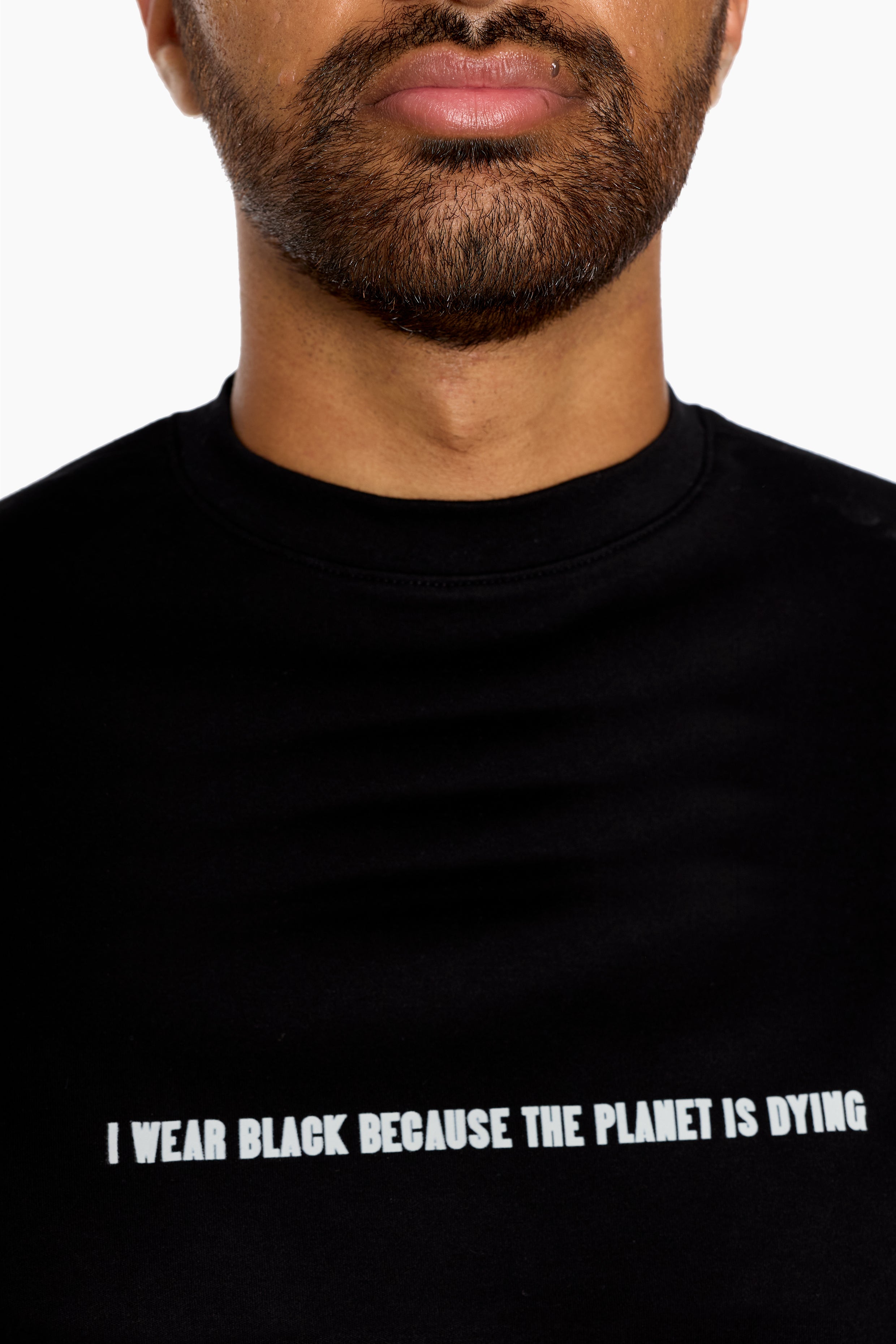 Person wearing a black t-shirt with a message about environmental  awareness. "I wear black because the planet is dying" 
