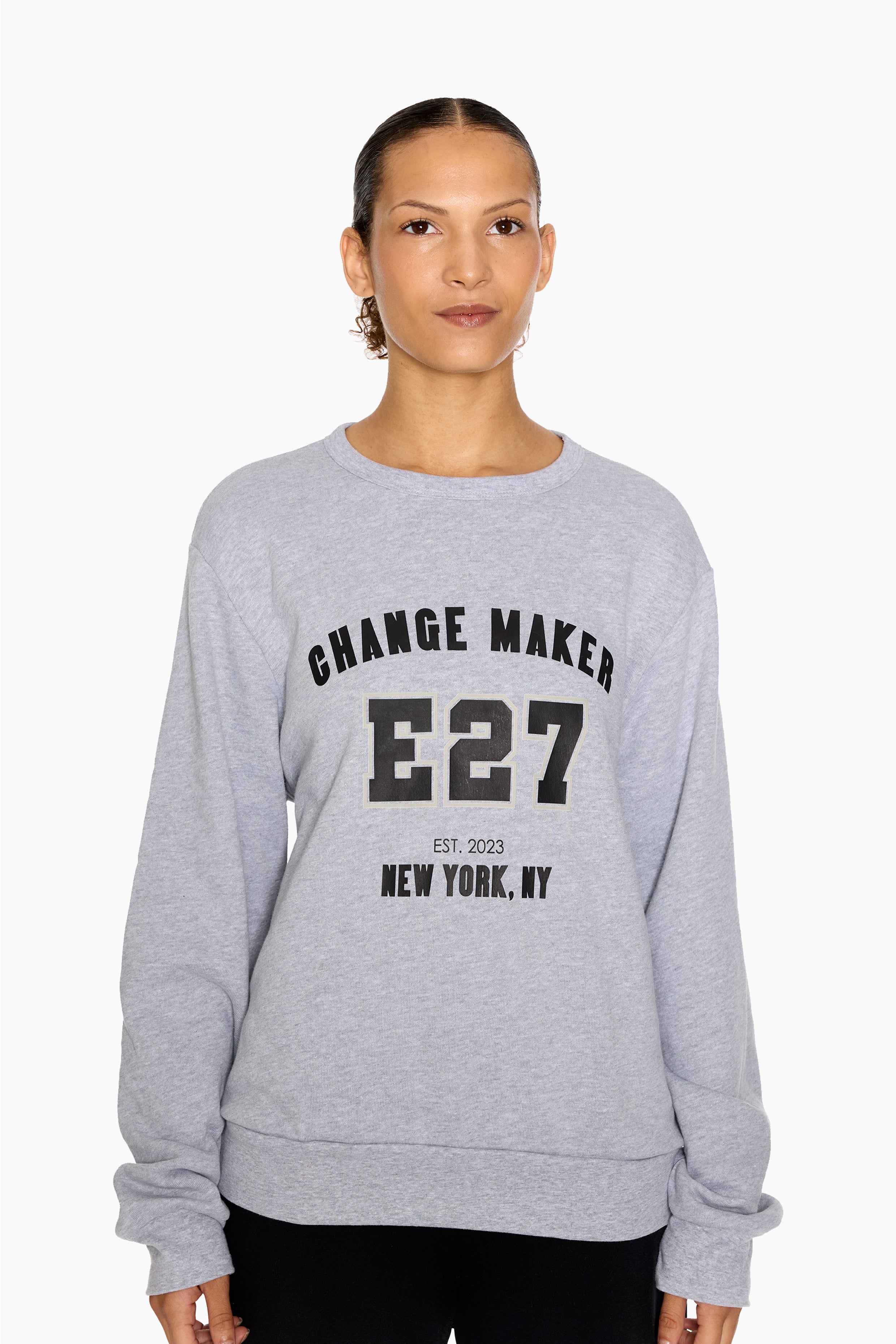 Person wearing a gray sweatshirt with 'Change Maker E27' text on a white background