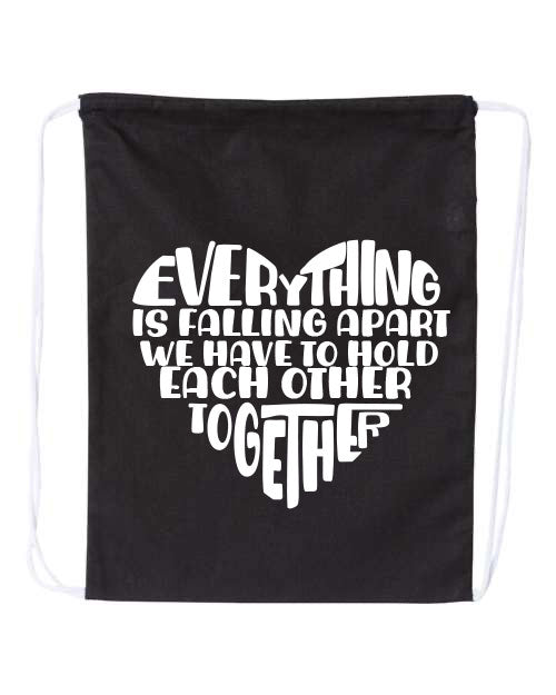 Black drawstring bag with EVerything Is Falling Apart We Have To Hold Each Other Together in white text on a white background