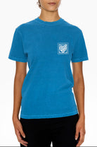 Person wearing a blue Eleven27 t-shirt with a heart stamp logo on a white background