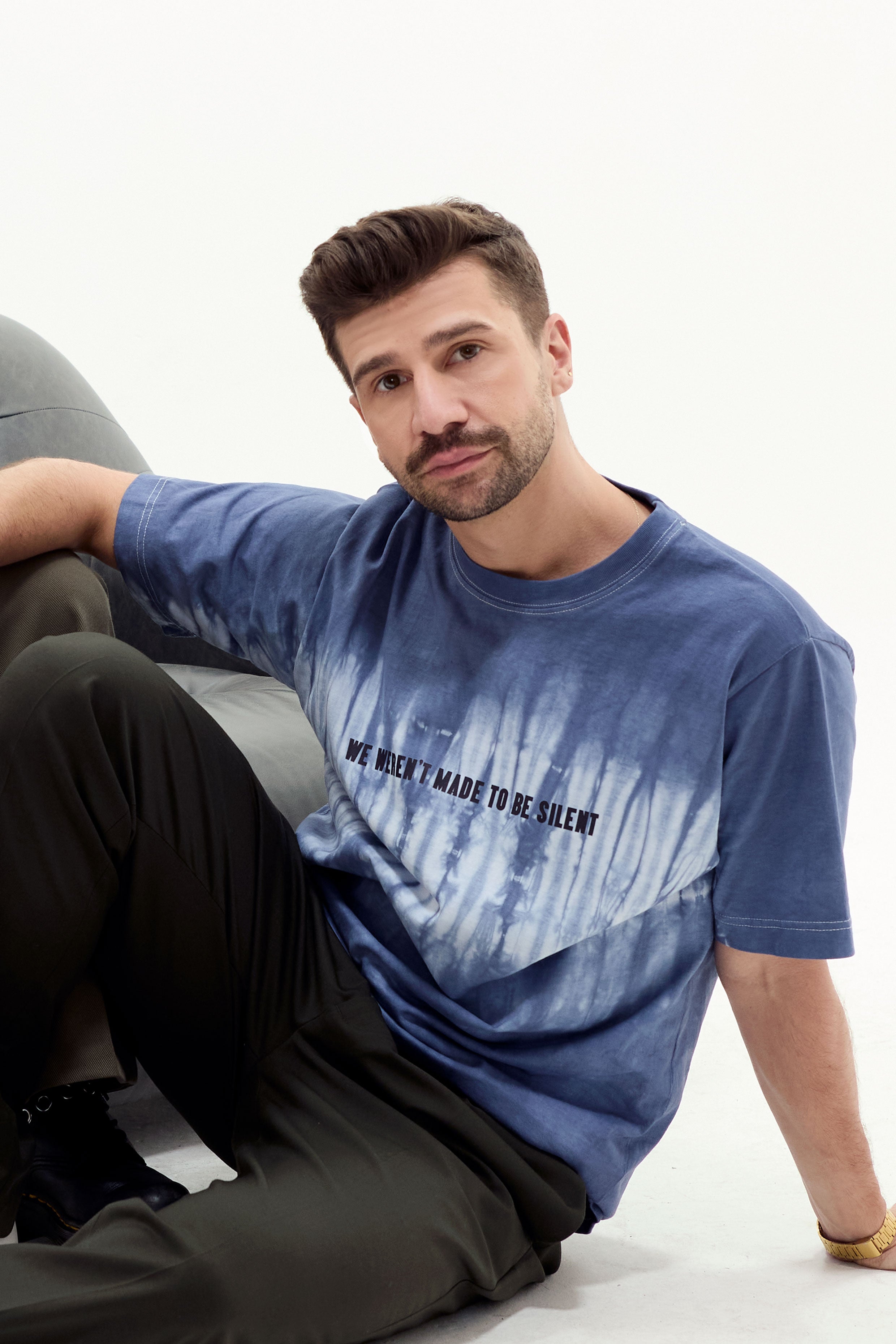 Model in navy and white tie dye tshirt with "We Weren't Meant To Be Silent" text. White background. Eleven27 brand
