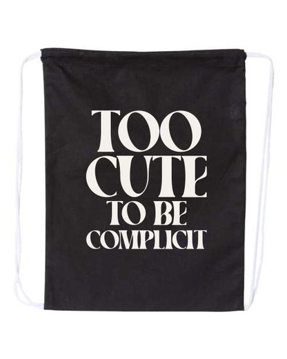 Black drawstring bag with white text 'Too Cute to be Complicit' on a white background