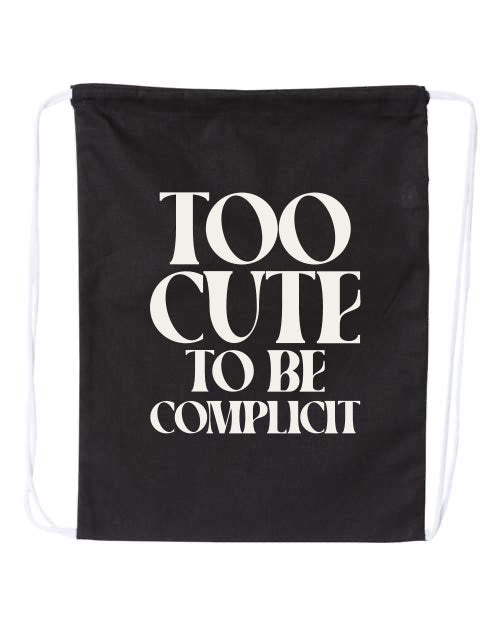 Black drawstring bag with white text 'Too Cute to be Complicit' on a white background