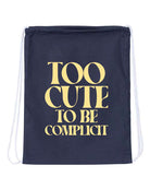 Navy drawstring bag with 'Too Cute to Be Complicit' text in gold on a white background